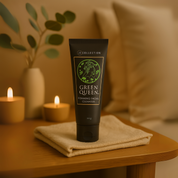 Tube of 'Green Queen' gentle foaming facial cleanser on a towel with candles and a plant in the background