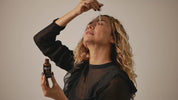 woman applying Jo Collection Vitamin C with hyaluronic acid and vitamin e to her face with a dropper