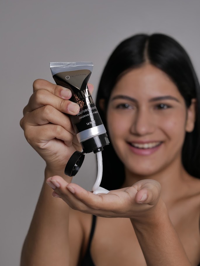 woman pouring Jo Collections Moisture Boost Hand cream into her hands and smiling