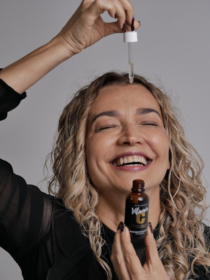 woman holding dropper for Jo Collection Vitamin C serum