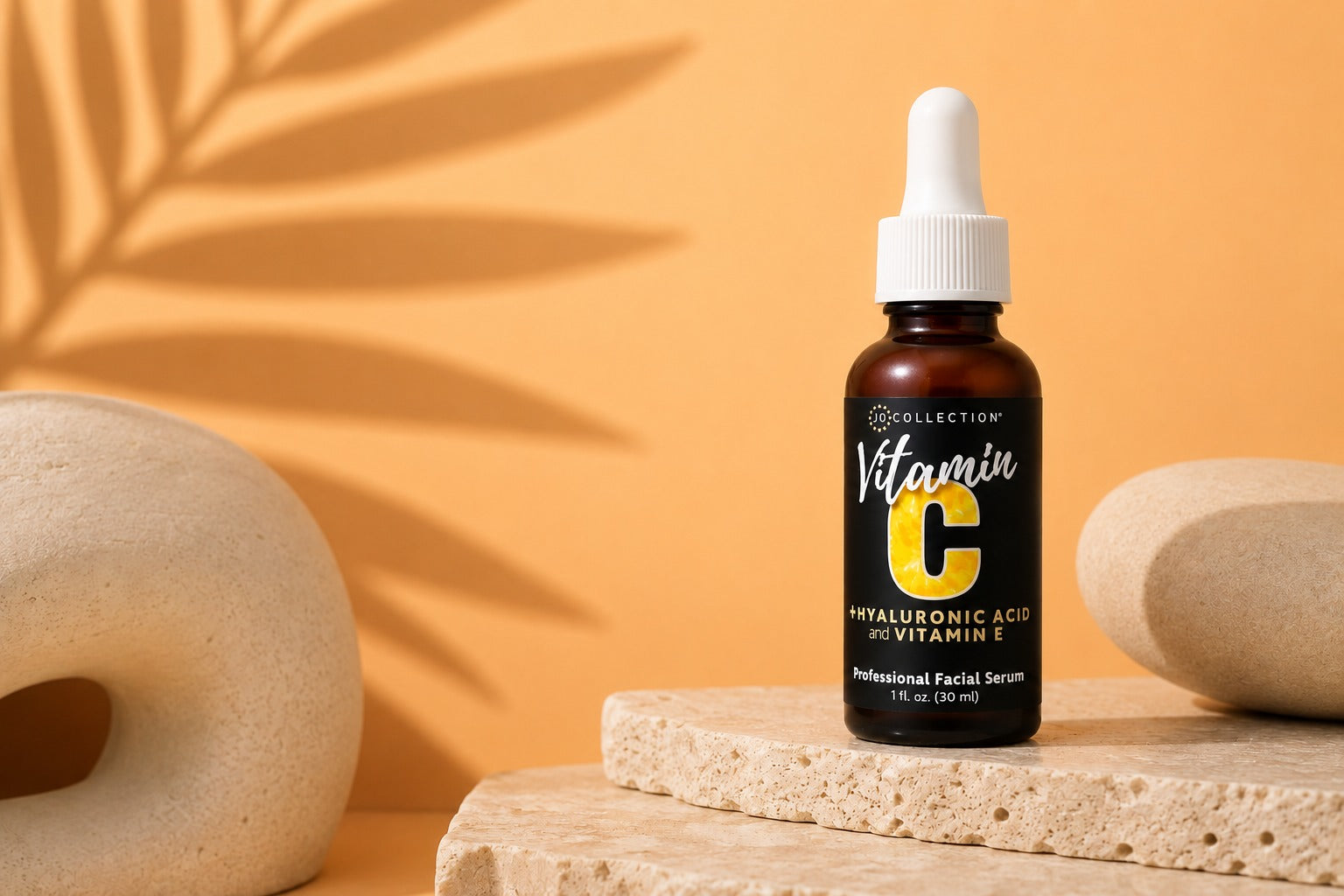 Jo Collection Vitamin C serum with hyaluronic acid and vitamin E on a warm orange background.